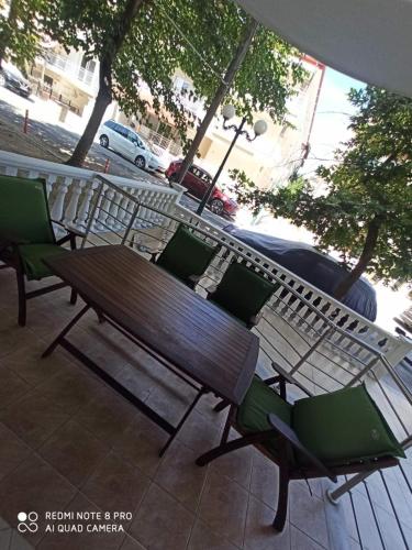 a wooden bench and chairs on a patio at JnB in Paralia Katerinis