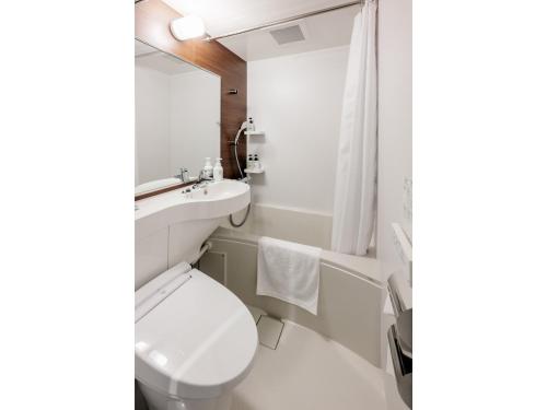 a white bathroom with a toilet and a sink at Smile Hotel Okayama - Vacation STAY 60155v in Okayama
