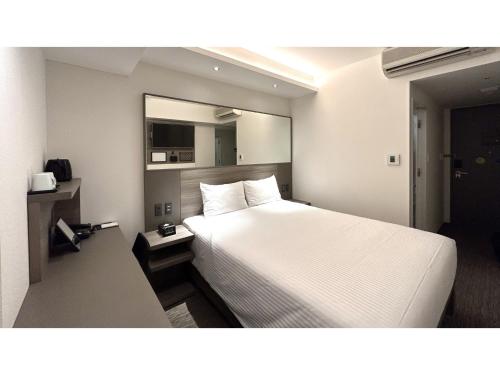 a hotel room with a white bed and a mirror at Smile Hotel Sapporo Susukino Minami - Vacation STAY 60199v in Sapporo