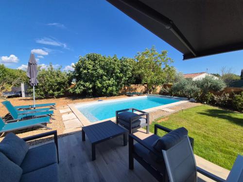 un patio avec des chaises et une piscine dans l'établissement Villa neuve avec piscine, à Régusse