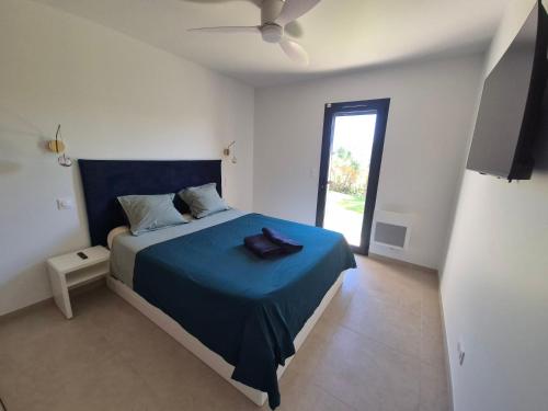a bedroom with a bed with a blue blanket at Villa neuve avec piscine in Régusse