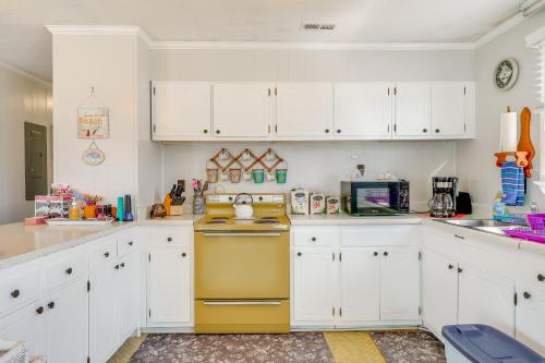 a kitchen with white cabinets and a yellow stove at 1 Mi to Avalon Pier Charming Coastal Cottage! in Kill Devil Hills