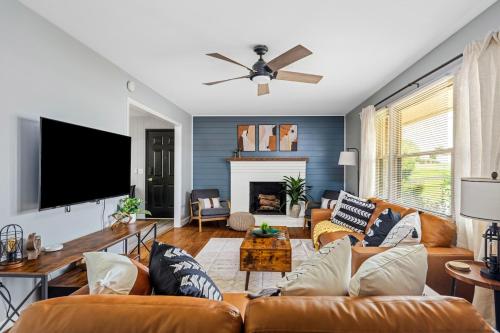 a living room with orange couches and a flat screen tv at Liberty Lodge in Lynchburg