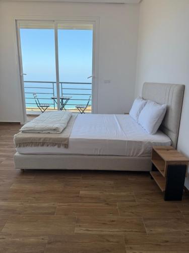 a bedroom with a bed and a large window at La Ola 