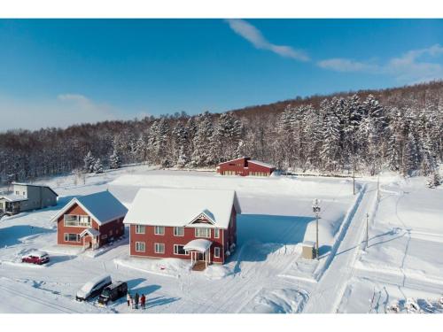 an aerial view of a house in the snow at Hotel Hanafuji Inn - Vacation STAY 82410v in Nakafurano
