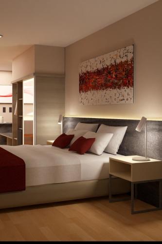 a bedroom with a large bed with red pillows at Ramada Suites by Wyndham Asuncion Aeropuerto in Asuncion
