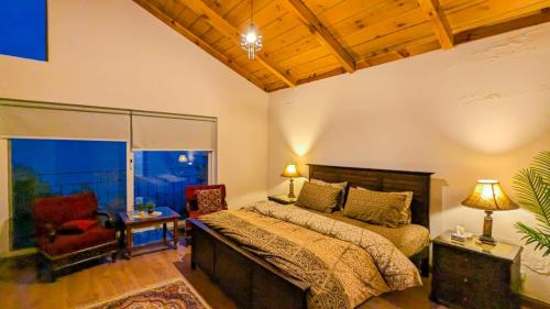 a bedroom with a large bed and a red chair at Haven Lodge Khaira Gali - Pine Ridge Residences #4 in Khaira Gali
