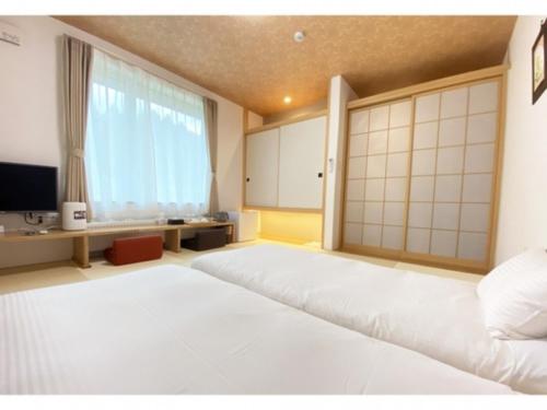 a large white bed in a room with a large window at Hotel Hanafuji Inn - Vacation STAY 82507v in Nakafurano