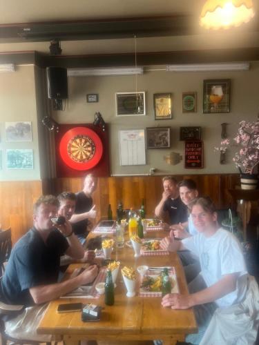 a group of people sitting around a wooden table at Hotel-Eetcafé d'Olde Heerd in Balkbrug