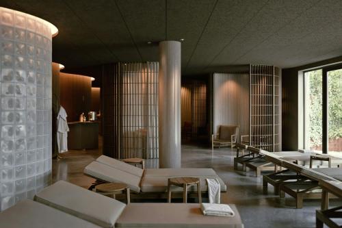 a lobby with tables and chairs in a building at Hagastrand, Autograph Collection in Solna