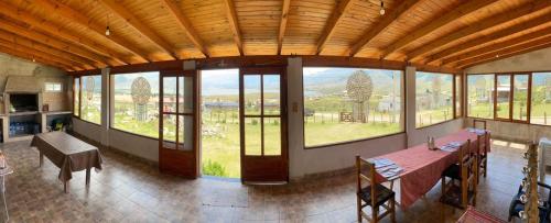 Habitación grande con mesa y algunas ventanas. en Casa La Bustamante, en El Mollar