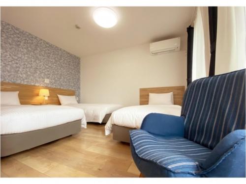 a hotel room with two beds and a couch at Hotel Hanafuji Inn - Vacation STAY 82522v in Nakafurano