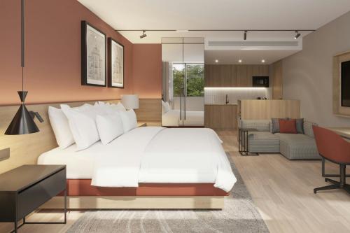 a bedroom with a white bed and a living room at Residence Inn by Marriott Lisbon in Lisbon