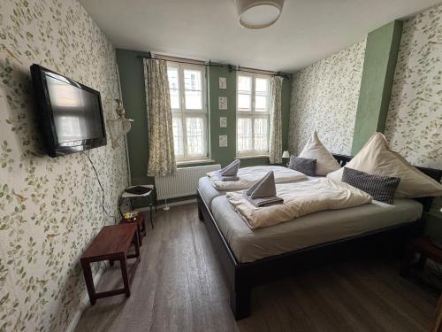 a bedroom with a bed and a tv on the wall at Himmel & Hölle Pölkenstraße in Quedlinburg