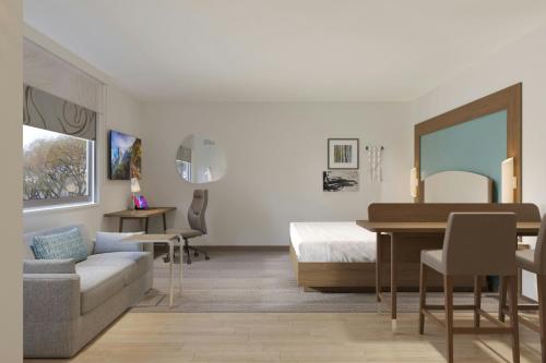 a bedroom with a bed and a table and a couch at Element Opelika Auburn in Opelika