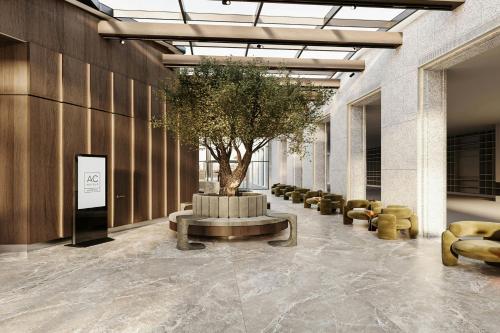 a lobby with a tree and a table and chairs at AC Hotel by Marriott Vilnius in Vilnius