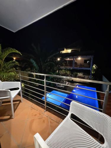 a balcony with white chairs and blue lighting on a building at Los Gallos - Suite superior in Lo de Marcos