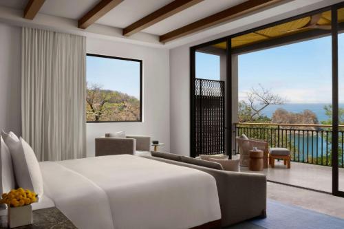 a bedroom with a large bed and a balcony at Nekajui, a Ritz-Carlton Reserve Residences in Liberia