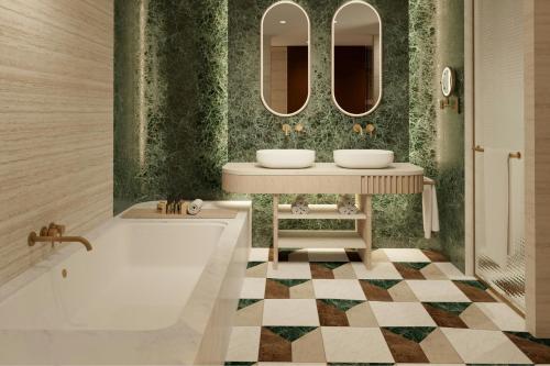 a bathroom with two sinks and a tub and mirrors at The Landmark Nicosia, Autograph Collection in Nicosia