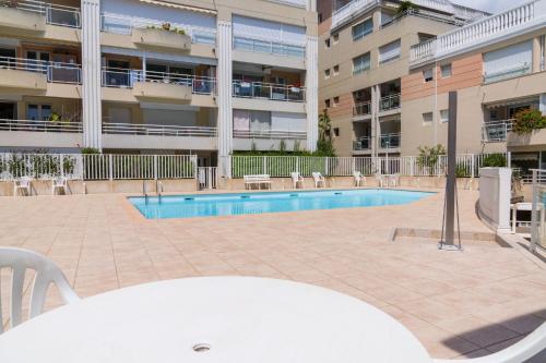 - une piscine en face d'un immeuble dans l'établissement Charmant 2p, piscine, clim, à 5 min de la plage, à Vallauris