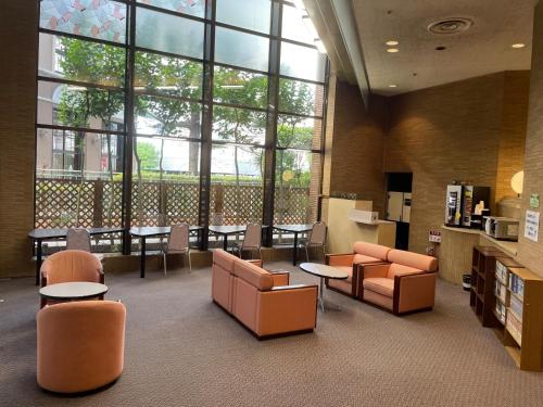 a library with chairs and tables and a large window at Smile Hotel Yonago - Vacation STAY 61096v in Yonago