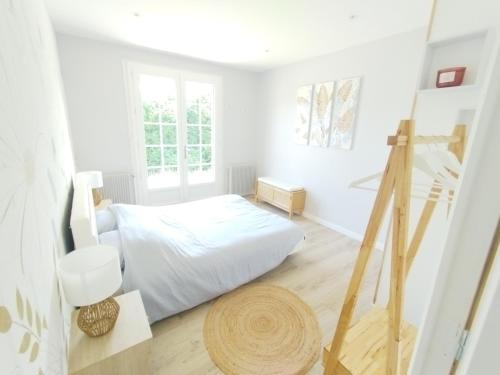 a white bedroom with a bed and a window at Val de la Lacquette in Enquin-les-Mines