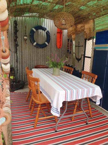 a table and chairs on a porch with a striped table cloth at Casita en Fontán in Sada