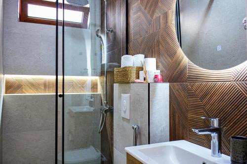 a bathroom with a shower and a sink and a mirror at Riian Luxury Apartments in Ulcinj