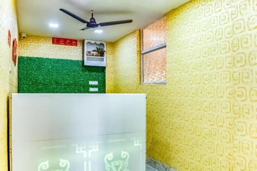 a refrigerator in a room with a yellow wall at Hotel O S&h Residency Bahadalpur Railway Station in Khandagiri