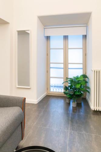 a living room with a couch and two plants at Turin Central Carlo Felice in Turin