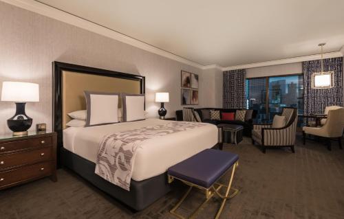 a bedroom with a large bed and a living room at Caesars Palace Hotel & Casino in Las Vegas