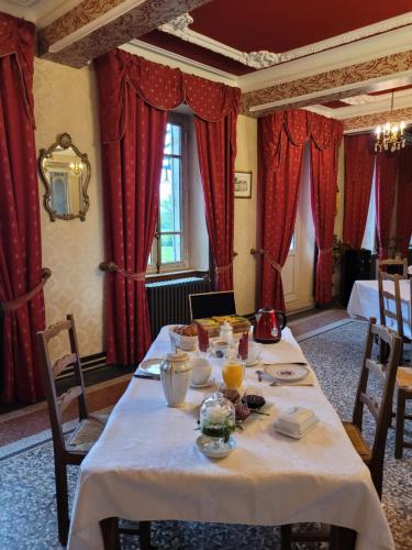 a dining room with a table with food on it at Château St Sulpice Chambre Porcelaine in Condal