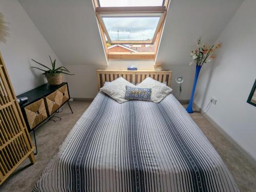 a large bed in a room with a window at Airy coastal courtyard house in Parkstone