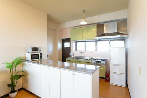 a kitchen with white cabinets and a white refrigerator at -3F - Vacation STAY 19502 in Uruma