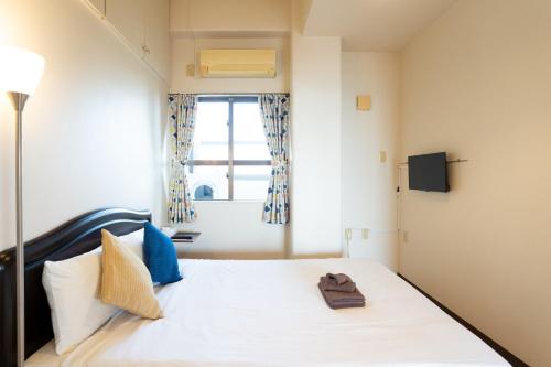 a bedroom with a white bed with a window at -3F - Vacation STAY 19502 in Uruma