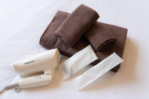 a hair dryer and a razor and towels on a bed at -3F - Vacation STAY 19502 in Uruma