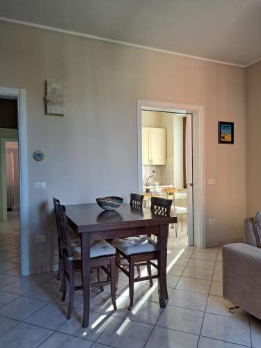 a dining room with a wooden table and chairs at Casa Prinz in Marotta