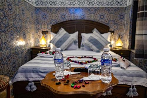 a bedroom with a bed with two water bottles on a table at Riad Hikaya - Fes Story in Fès