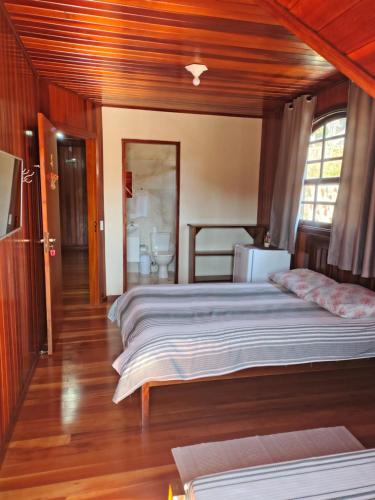 a bedroom with a large bed in a room at Casa do Trem Suítes in Campos do Jordão