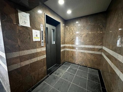 un couloir avec une porte et un sol carrelé dans l'établissement Tokan Nakanoshima Castel - Vacation STAY 19496, à Sapporo