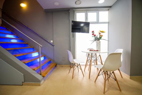 a room with a staircase with a table and chairs at bella Kerkyra in Agios Rokkos