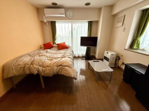 - une chambre dotée d'un lit avec des oreillers orange dans l'établissement Tokan Nakanoshima Castel - Vacation STAY 19496, à Sapporo