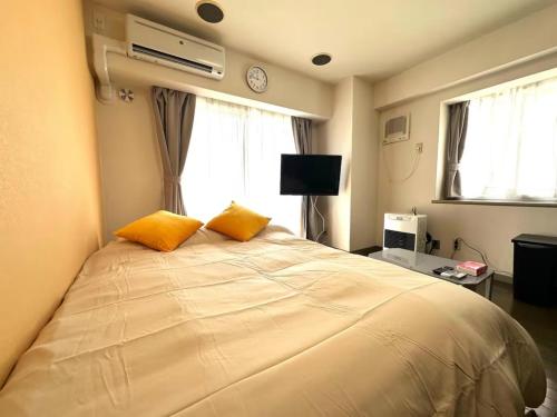 a bedroom with a large bed with two orange pillows at Tokan Nakanoshima Castel - Vacation STAY 19495 in Sapporo