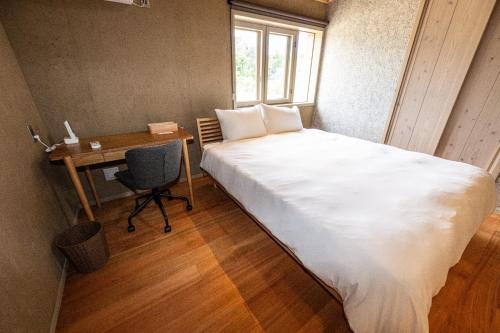 a small bedroom with a bed and a desk and a window at Shiraho Villa Square Court - Vacation STAY 63025v in Shiraho