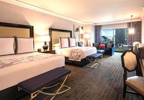a hotel room with two beds and a couch at Caesars Palace Hotel & Casino in Las Vegas