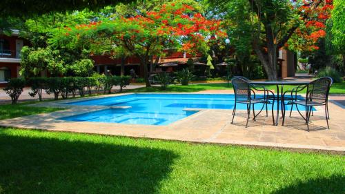 uma mesa e cadeiras ao lado de uma piscina em Meson del Valle em Zamora de Hidalgo