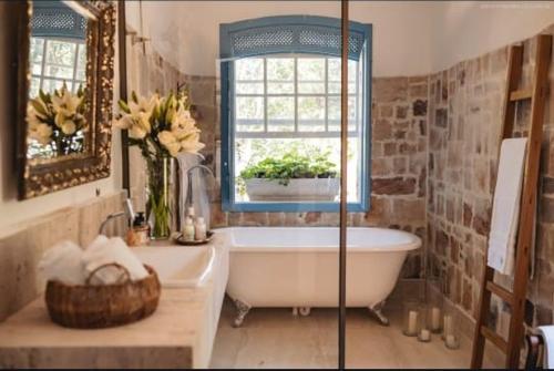 a bathroom with a tub and a sink and a window at Chateau Tiradentes in Tiradentes