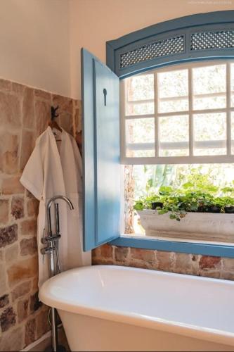 a bathroom with a sink and a window and a tub at Chateau Tiradentes in Tiradentes