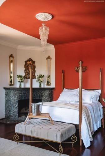 a bedroom with red walls and a bed and a fireplace at Chateau Tiradentes in Tiradentes