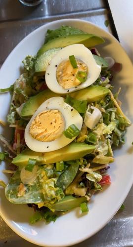 a white plate with a salad with eggs on it at Hotel-Eetcafé d'Olde Heerd in Balkbrug